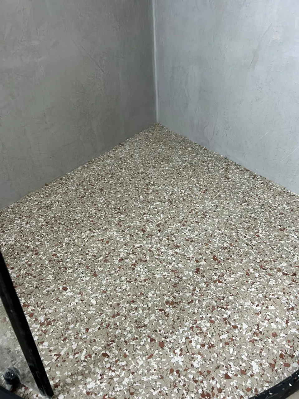Room floor covered in cream, white and red flake epoxy